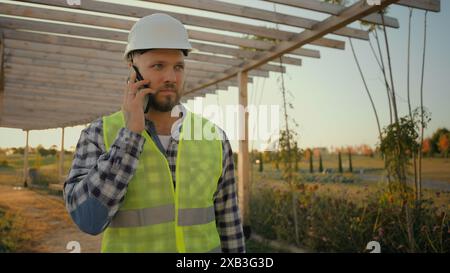 Erfahrener kaukasischer Mann männlicher Mann Uniform Geschäftsmann Spezialist Umweltingenieur Anrufe sprechendes Handy Smartphone Anruf Besprechen Sie das Geschäft Stockfoto