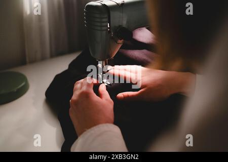 Zugeschnittenes Bild einer Frau, die Stoff in der Maschine näht Stockfoto