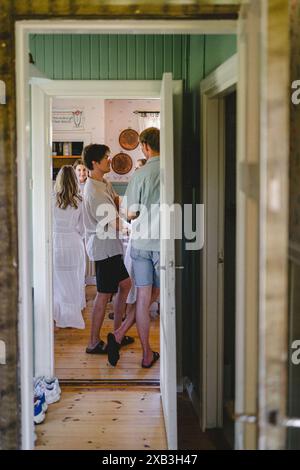 Freunde, die im Zimmer sprechen, durch die Tür gesehen Stockfoto