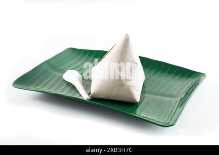Nasi Lemak in Papier auf einem Teller in mittlerer Nahaufnahme gewickelt Stockfoto