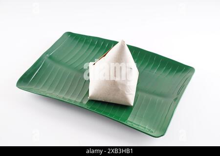 Nasi Lemak in Papier auf einem Teller in mittlerer Nahaufnahme gewickelt Stockfoto