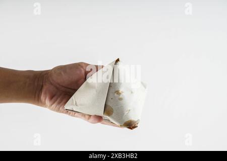 Hand hält Nasi Lemak in Papier gewickelt Stockfoto