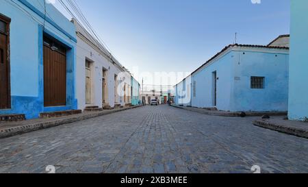 362 einstöckige Kolonialgebäude auf beiden Seiten der Marin Aguero Street, vom Plaza Carmen Square aus gesehen, wo sich die Einheimischen bei Sonnenuntergang entspannen. Camaguey-Kuba. Stockfoto