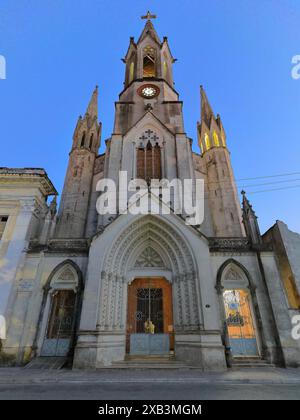 369 Neogotische Heilige Herzkirche aus den Jahren 1912-19, nach Norden ausgerichtete Hauptfassade mit ausgestelltem Portal und hohem Glockenturm in der frühen Nacht. Camaguey-Kuba. Stockfoto