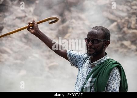 Ortskundiger Reiseleiter traditionell gekleidet und zeigt heiße geothermische vulkanische natürliche Quellen mit dampfendem Pool und kleinen bunten Seen, Geysiren und Bächen Stockfoto