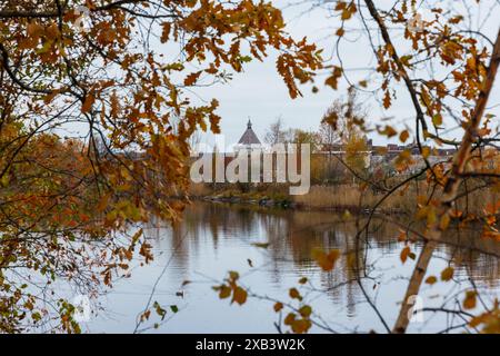 Herbstlandschaft mit verschwommenen Bäumen, Ästen und Festung Shlisselburg im Hintergrund Stockfoto