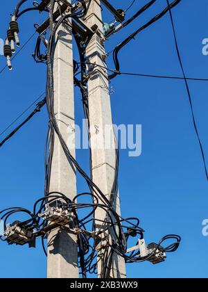 Betonsäulen mit elektrischen Drähten, Kabelspulen und Schalteinrichtungen. Stromübertragung, Stromversorgung. Ansicht von unten Stockfoto