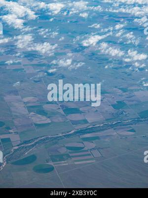 Blick auf Ackerland von einem Flugzeugfenster über die USA. Formen, die durch Bewässerungssysteme mit zentrischen Drehzapfen erzeugt werden. Stockfoto