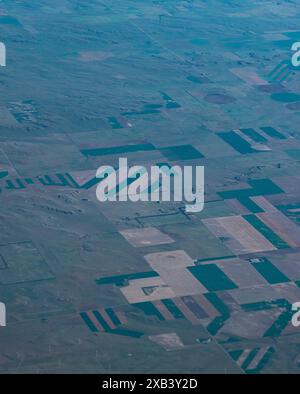 Blick auf Ackerland von einem Flugzeugfenster über die USA. Formen, die durch Bewässerungssysteme mit zentrischen Drehzapfen erzeugt werden. Stockfoto