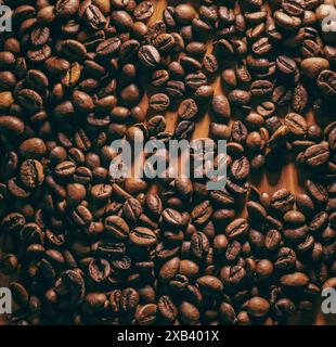 Geröstete Kaffeebohnen in loser Schüttung auf einem Holztisch Stockfoto