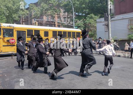 Chassidische Lehrer und ältere Schüler tanzen den lag B'Omer-Feiertag. In Williamsburg, Brooklyn, New York, 2024. Stockfoto