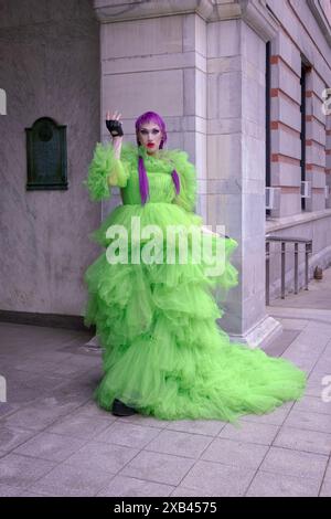Ein schlanker, großer Mann im Drag-and-Drag-and-Drop mit einem verzierten grünen Kleid und lila Haaren bei der Pride Parade 2024 in Poughkeepsie, Duchess County, N.Y. Stockfoto