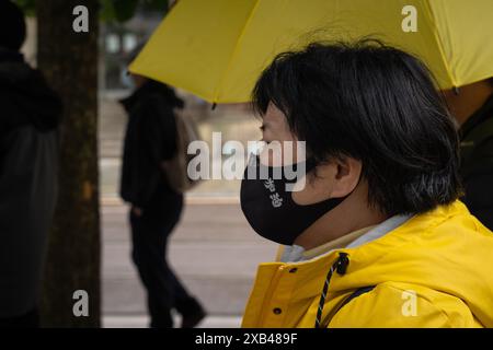 Manchester, Großbritannien. Juni 2024. Eine Frau wurde in Gelb gekleidet gesehen und trug eine Maske mit dem chinesischen Wort „Hong Kong“, auf der in Manchester marschierte. Die Bevölkerung Hongkongs hielt vor fünf Jahren einen Protestmarsch im Stadtzentrum von Manchester ab, um der Demokratiebewegung in Hongkong zu gedenken, eine der größten Demonstrationen in der Geschichte Hongkongs. was später dazu führte, dass sich die Polizei verkrampft und viele Festnahmen verhaftet wurden, was dazu führte, dass Zehntausende von Bürgern die Stadt verließen und nach Großbritannien, Taiwan und mehr zogen. Quelle: SOPA Images Limited/Alamy Live News Stockfoto