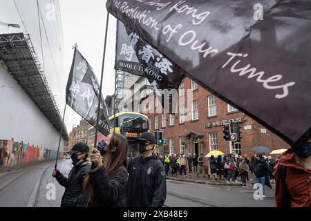 Manchester, Großbritannien. Juni 2024. Demonstranten werden mit Flaggen gesehen, auf denen steht: "Befreien Sie Hongkong, Revolution unserer Zeit", die von der Bewegung damals wild benutzt wurde, als sie in Manchester marschierte. Die Bevölkerung Hongkongs hielt vor fünf Jahren einen Protestmarsch im Stadtzentrum von Manchester ab, um der Demokratiebewegung in Hongkong zu gedenken, eine der größten Demonstrationen in der Geschichte Hongkongs. was später dazu führte, dass sich die Polizei verkrampft und viele Festnahmen verhaftet wurden, was dazu führte, dass Zehntausende von Bürgern die Stadt verließen und nach Großbritannien, Taiwan und mehr zogen. Quelle: SOPA Images Limited/Alamy Live News Stockfoto