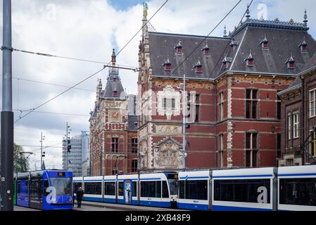 31.05.2024, Amsterdam, Niederlande Straßenbahn auf der Straße. Im Hintergrund befindet sich der Hauptbahnhof Amsterdam Stockfoto