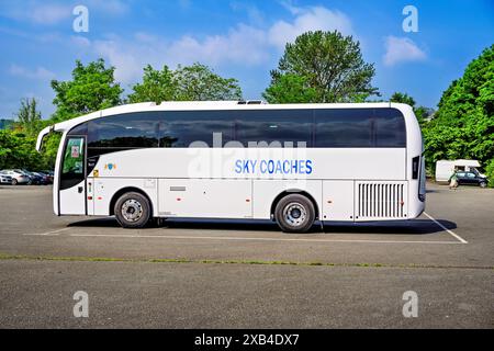 Conwy Wales Uk 06-01-2024. Moderner weißer Reisebus parkte an einem sonnigen Tag auf einem Außenparkplatz unter einem klaren blauen Himmel. Stockfoto