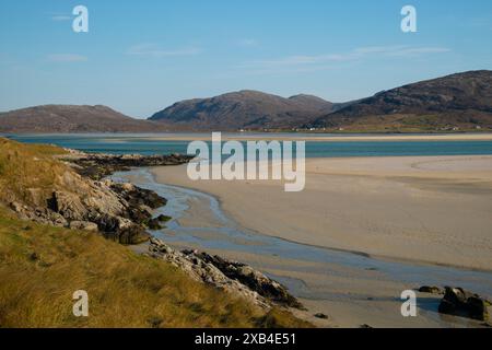 Ein Blick auf das Meer und die fernen Hügel bei Ebbe vom Luskentyre Beach an der Westküste der Isle of Harris. Stockfoto