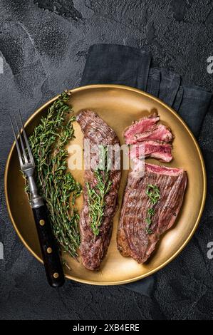 BBQ gegrilltes Bavette Bavet Rindfleisch Steak mit Kräutern auf einem Teller. Schwarzer Hintergrund. Draufsicht. Stockfoto