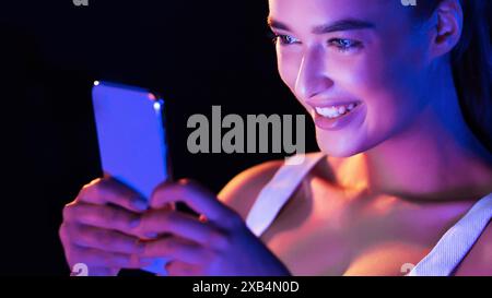 Junge Frau, die nachts ein Smartphone benutzt, Großaufnahme Stockfoto