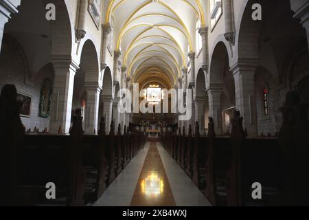 Im Inneren der Katharinenkirche oder der Mitternachtskirche in Bethlehem sind die architektonischen Merkmale und die Spiegelung von Buntglasfenstern auf dem Boden zu sehen. Stockfoto