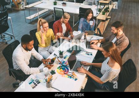 Gruppe von Personen, die am Tisch an Laptops arbeiten Stockfoto