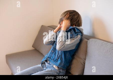 Müdes, krankes Teenager-Kind, das sich mit akademischem Druck und persönlichem Wachstum auseinandersetzt, Trost sucht in einem Moment stille Reflexion, Kindheitsstress Stockfoto