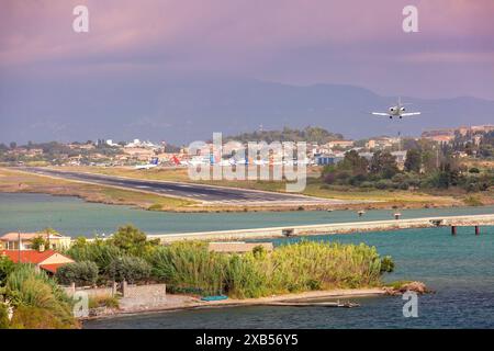 Blick auf den internationalen Flughafen Korfu in Griechenland mit Flugzeugen auf der Landebahn und einer Landung Stockfoto
