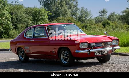 Stony Stratford, UK - 2. Juni 2024: 1972 roter Ford Capri Oldtimer, der auf einer britischen Landstraße fährt Stockfoto