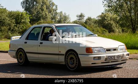 Stony Stratford, Großbritannien - 2. Juni 2024:1989 weißer Ford Sierra Saphir cosworth Oldtimer, der auf einer britischen Landstraße fährt Stockfoto