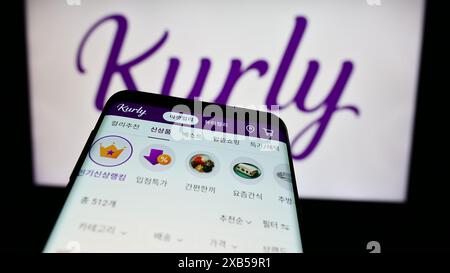 Mobiltelefon mit Website des südkoreanischen E-Commerce-Unternehmens Kurly vor dem Geschäftslogo. Fokussieren Sie sich oben links auf der Telefonanzeige. Stockfoto