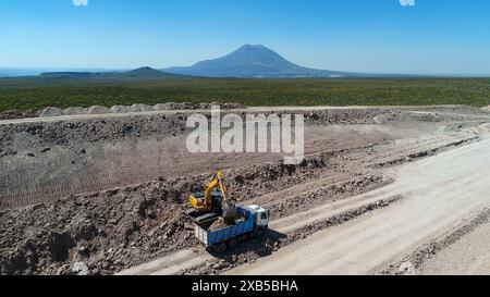 Bagger beladen Lkw von Steinen, im Straßenbau. Stockfoto