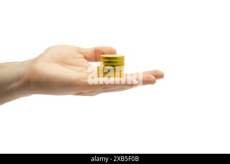 Männliche Hand, die Stapel von Schokoladenmünzen isoliert auf weißem Hintergrund hält, Hand hält einen Stapel von Münzen, Hand hält einen Stapel von goldenen Schokoladenmünzen Stockfoto