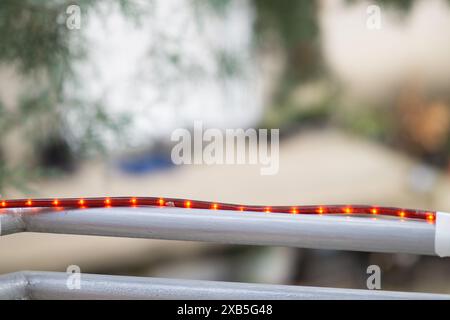 Weihnachtsröte Lichter, die an einem Zaun befestigt sind, schmücken zu Hause Stockfoto