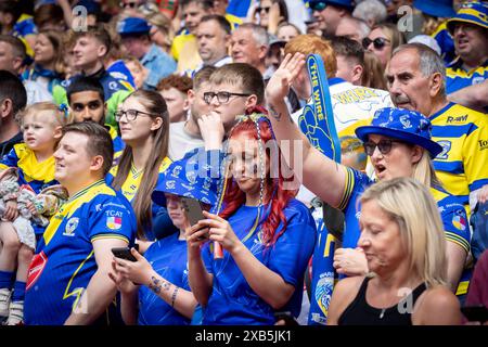 Das Finale des Betfred Challenge Cup 2024 im Wembley Stadium zwischen Warrington und Wigan. Warrington-Fan mit geflochtenem Haar überprüft ihr Handy Stockfoto