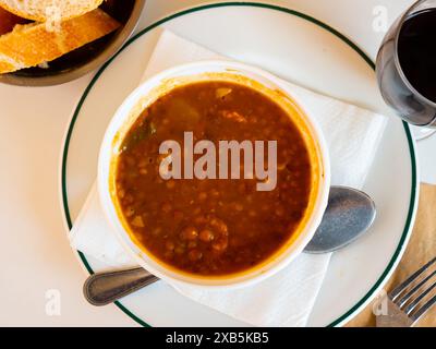 Auf dem Tisch wird ein spanischer Linseneintopf serviert Stockfoto