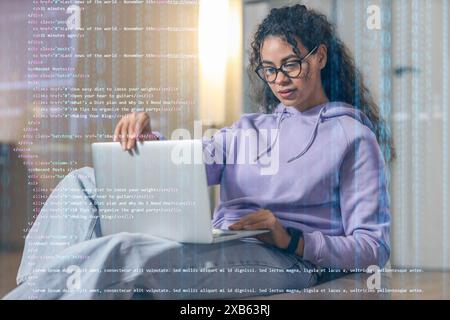 Weibliche afroamerikanische Programmiererin, die im Büro mit einem Laptop arbeitet Stockfoto