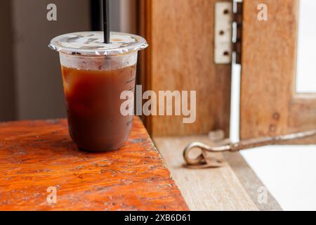Americano Eiskaffee in einer Plastiktasse auf einem Kaffeetisch Stockfoto