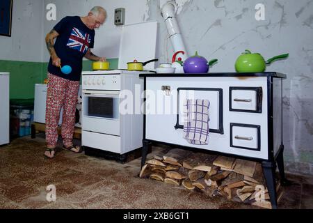 Reife männliche britische Expat in angemessener Kleidung kochen Essen in seiner Küche für andere Expats zala County ungarn Stockfoto