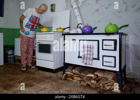 Reife männliche britische Expat in angemessener Kleidung kochen Essen in seiner Küche für andere Expats zala County ungarn Stockfoto