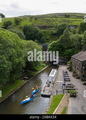 Kanufahrer verlassen den Standedge Tunnel auf dem Huddersfield Narrow Canal, der als eines der sieben Wunder der britischen Wasserstraßen beschrieben wird: Der Tunnel, der fast dreieinhalb Meilen lange, über 17 Jahre dauerte, um von Hand zu graben, wurde 1811 fertiggestellt und wurde mit 645 Fuß über dem Meeresspiegel zum längsten, tiefsten und höchsten Kanaltunnel Großbritanniens, der etwa 638 Meter unter den Pennines grub. Bilddatum: Montag, 10. Juni 2024. Stockfoto