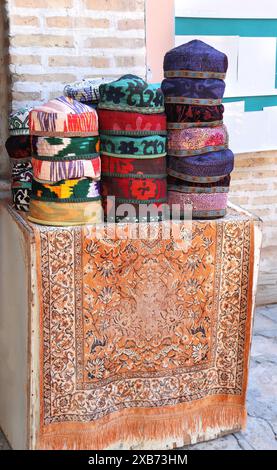 Bunte Schädelkappen auf einem Straßenbasar in der Altstadt von Samarkand, Usbekistan. Traditionelle usbekische Totenkopfmützen zum Souvenir-Shopping Stockfoto