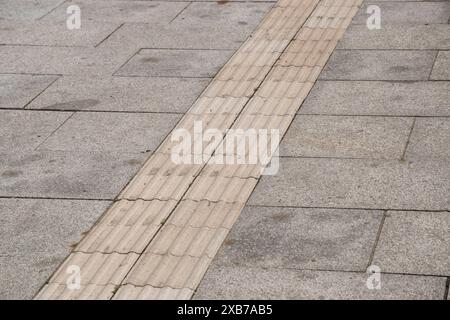 Spezielle Fliesen auf dem Fußweg, die für Blinde bestimmt sind Stockfoto