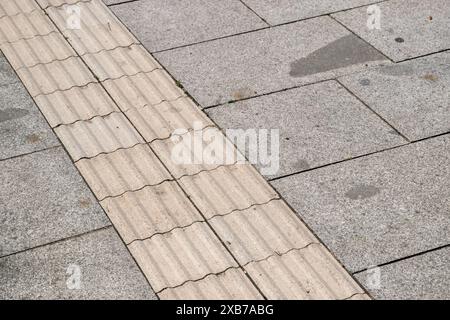Spezielle Fliesen auf dem Fußweg, die für Blinde bestimmt sind Stockfoto