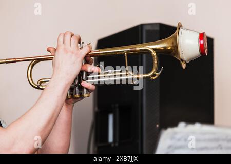 Trompete mit gerader Stummschaltung in Trompeterhänden. Hintergrundfoto mit Live-Musik Stockfoto