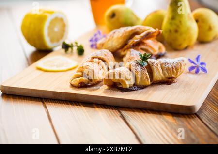Süßes Gebäck, Blätterteiggebäck mit Birnen, auf einem Holztisch. Stockfoto