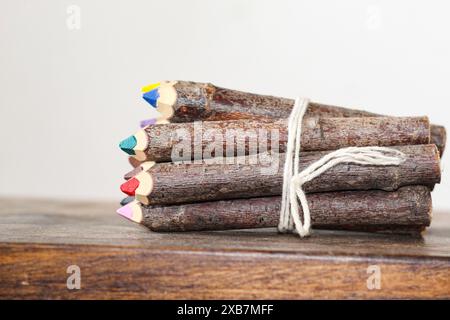 Die lebendigen Holzstifte, die mit einem Band auf einer Holzoberfläche gebunden sind. Stockfoto