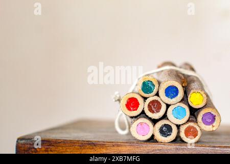 Die lebendigen Holzstifte, die mit einem Band auf einer Holzoberfläche gebunden sind. Stockfoto