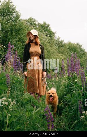 Ingwermädchen mit Ingwerhund auf dem Feld Stockfoto