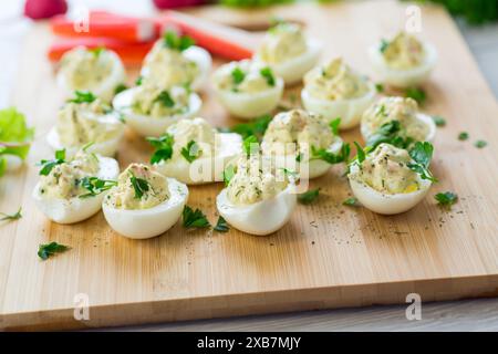 Gefüllte Eier, teuflierte Eier auf einem Holztisch. Stockfoto