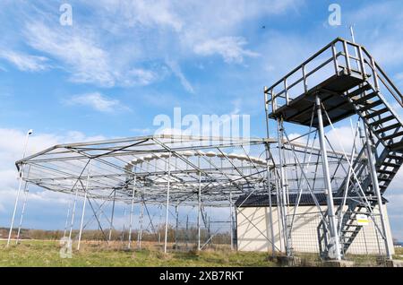 Eine massive Metallkonstruktion, die auf einem grasbewachsenen Feld steht Stockfoto